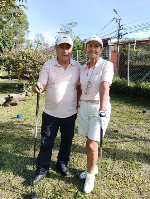 Una pareja de socios posa con sus palos