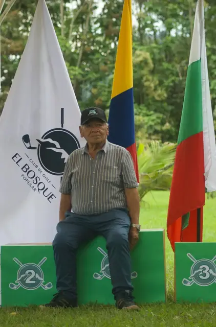 Un socio junto a la bandera del club y las de Colombia y Caldas